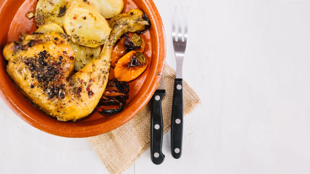 A traditional Moroccan chicken tagine served in a decorative earthenware pot, with tender chicken, olives, and preserved lemons.