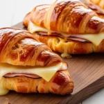 Freshly baked ham and cheese croissants on a rustic plate